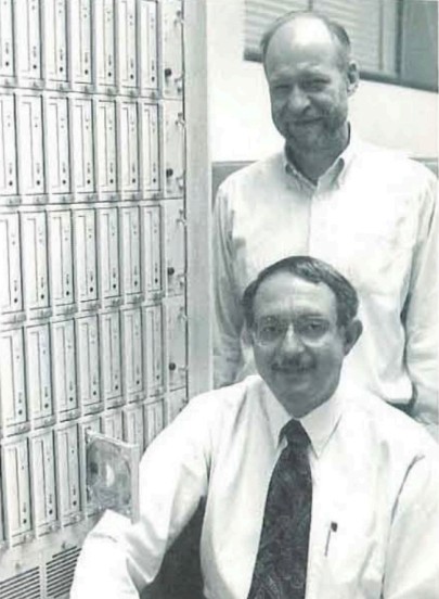 Two people in front of a CD-ROM server.
