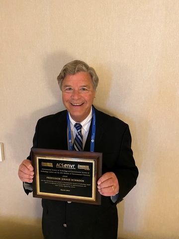 Jerry Schnoor holding plaque 