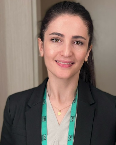Portrait. Dark haired woman in black sport coat with white shirt.