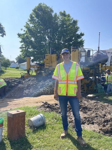 Man wearing bright yellow safety vest stands on a job site