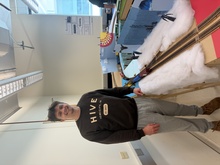 Man with dark hair poses next to elevated model train track