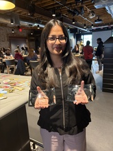 Woman with dark hair and glasses holds two glass plaques