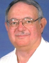 Head-and-shoulders portrait of a person wearing glasses against a blue background.