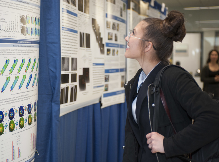 female student looking at research poster 