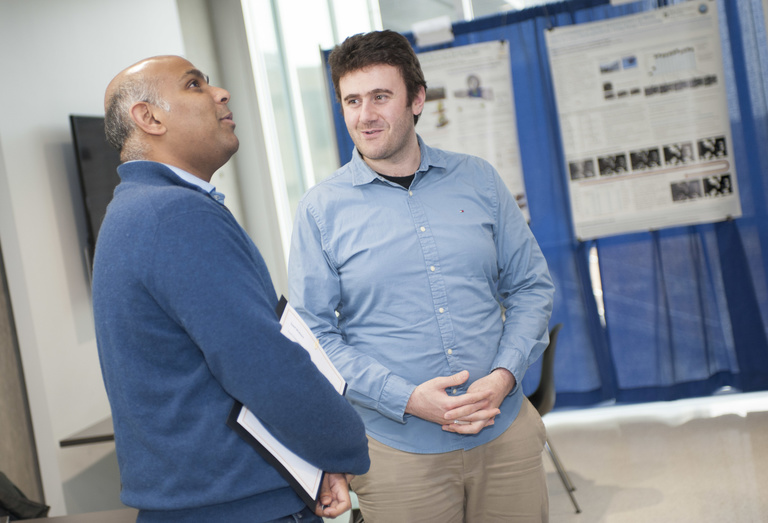 student and professor mubeen discussing poster