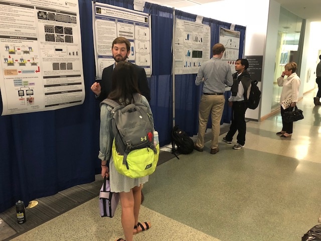 people talking in front of research posters 