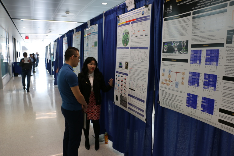 2 people looking at a research poster
