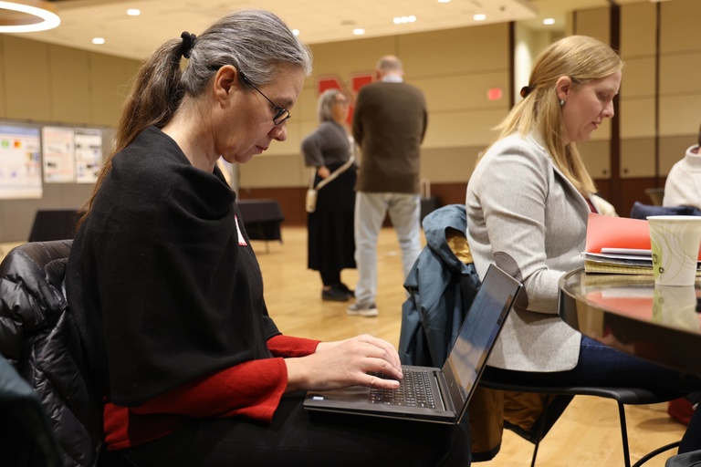 Person working on a laptop at a conference