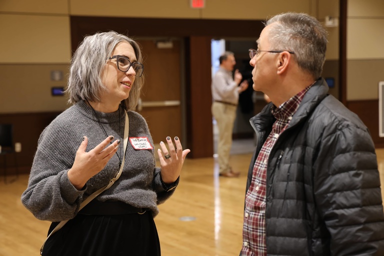 Two people talking at a conference