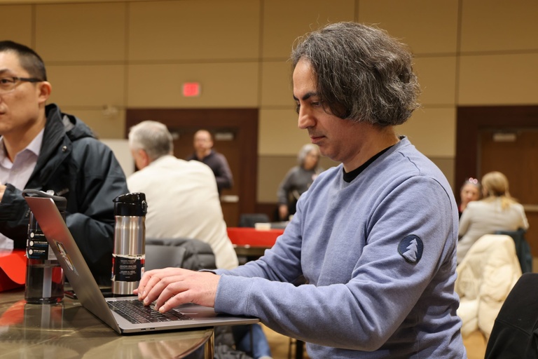 A person working on a laptop at a conference