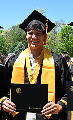 Caiden Atienza poses for a photo in the graduation cap and gown