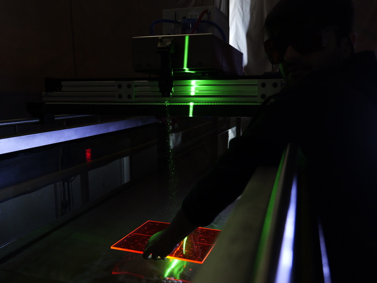 The laser beam from the particle image velocimeter (PIV) reflects off the acrylic calibration plate. The laser helps illuminate the particles in water to capture and study the flow field.