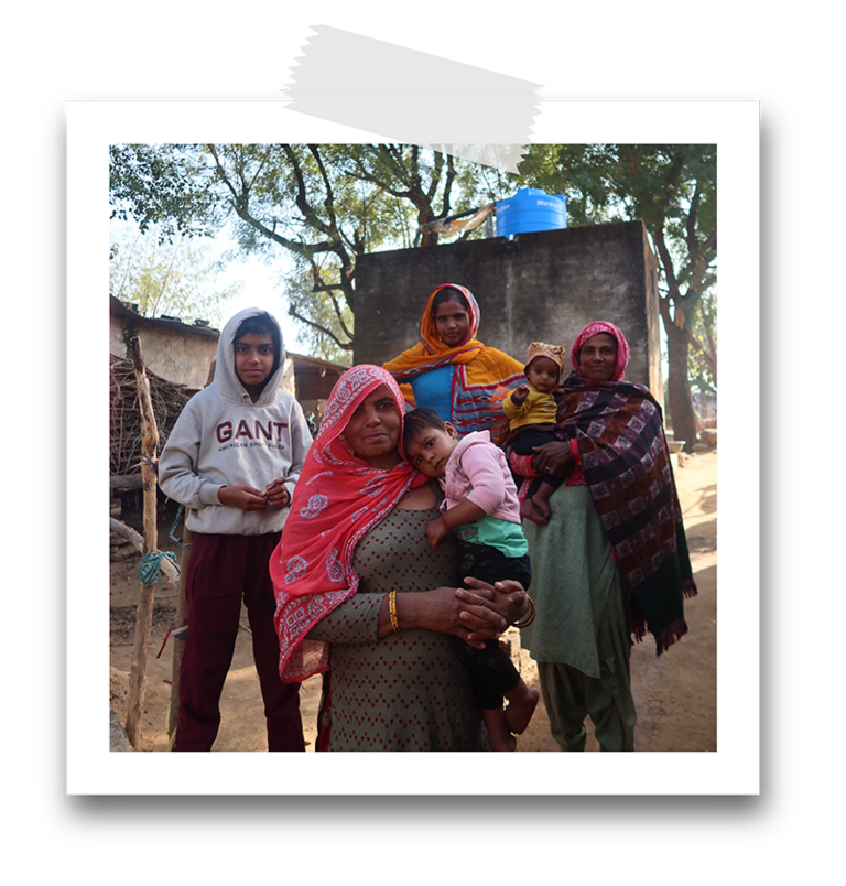 a small group of local women and children pose for a photo