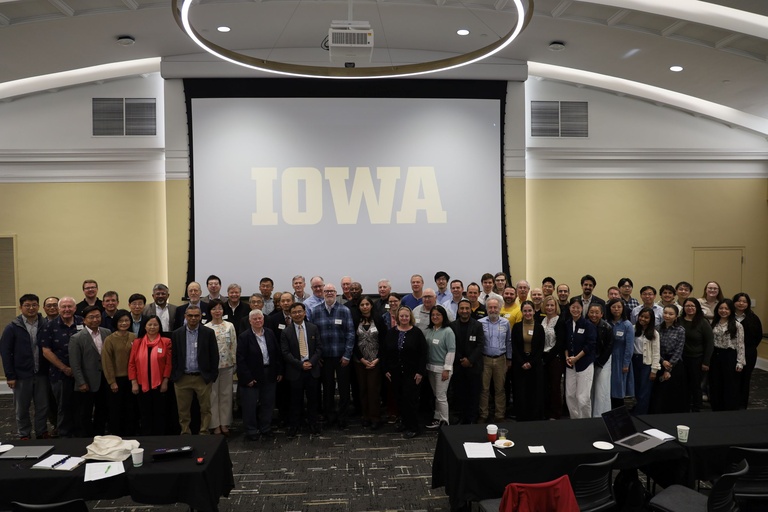 A group of people posing for a photo in front of an Iowa sign