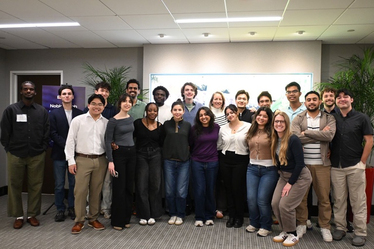 Group of 21 young adults wearing professional clothing stand posed