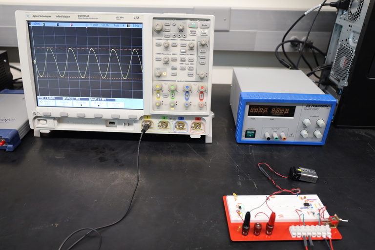 Two devices and circuit board sit on lab bench