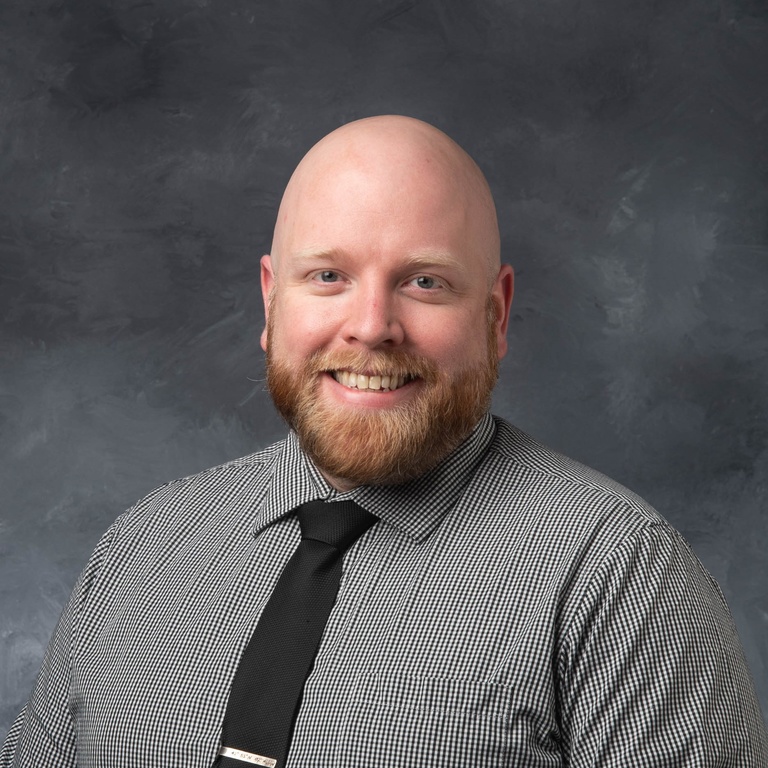 Portrait of Ryan Puhrmann, grey button down shirt and black tie