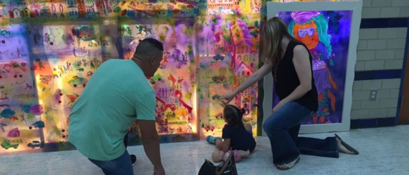A family viewing the interactive STEAM mural.
