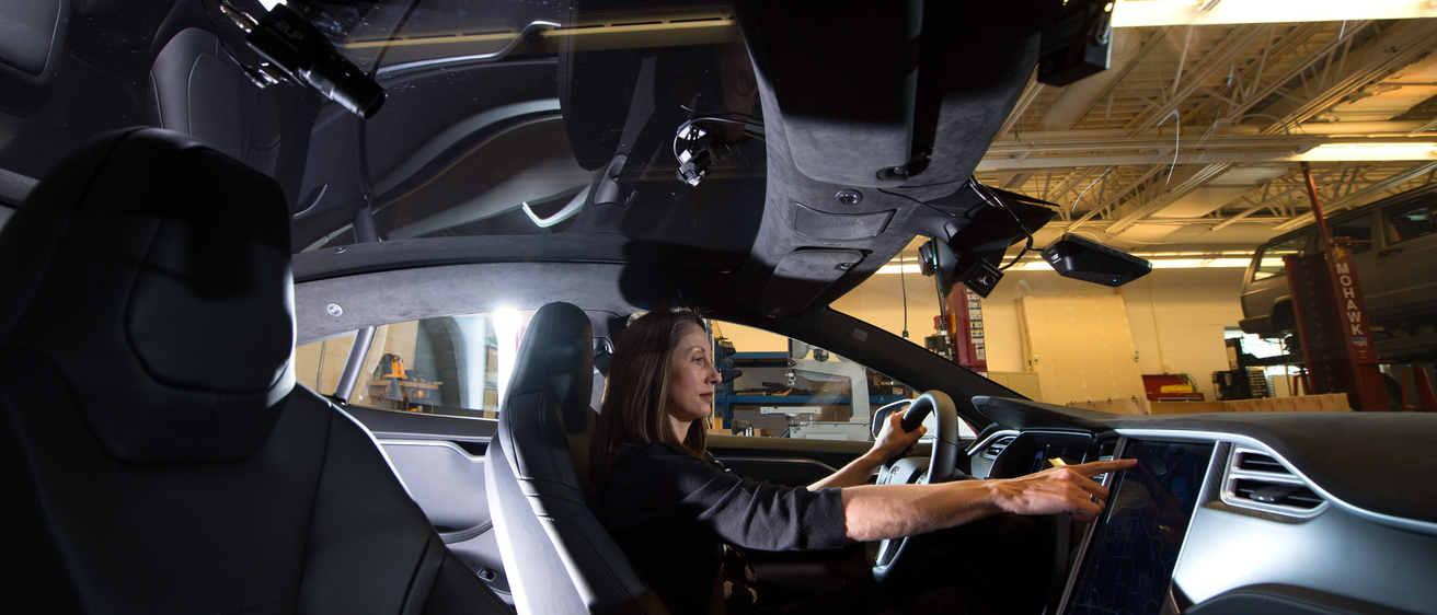 a woman is sitting in the drivers seat of a car equipped with artificial intelligence 