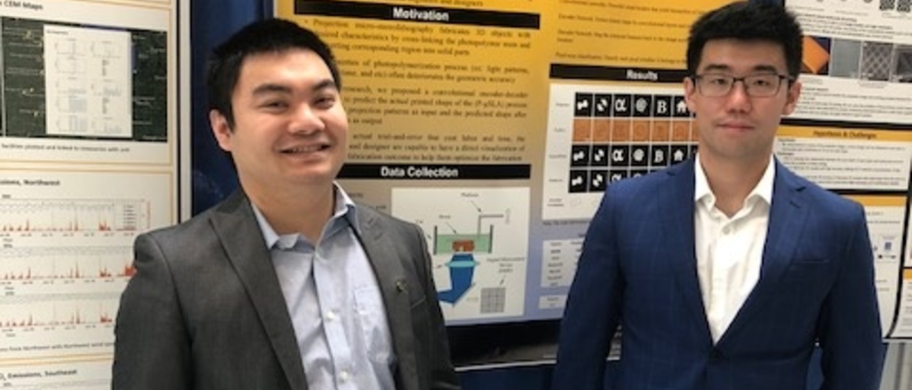 Two students posting in front of a research poster 
