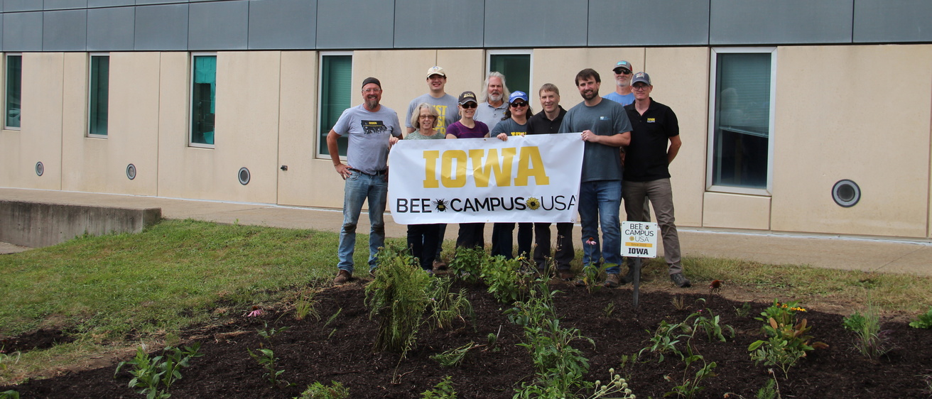 A group of people holding a "Bee Campus USA" sign