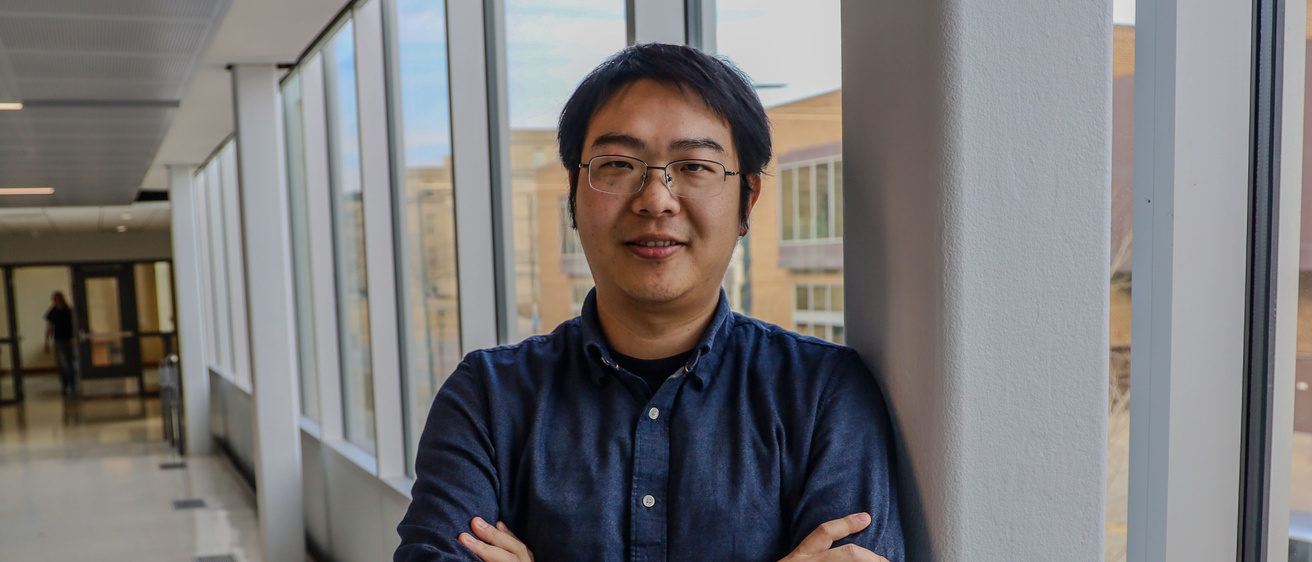 Chao Wang stands in the hallway at the College of Engeering