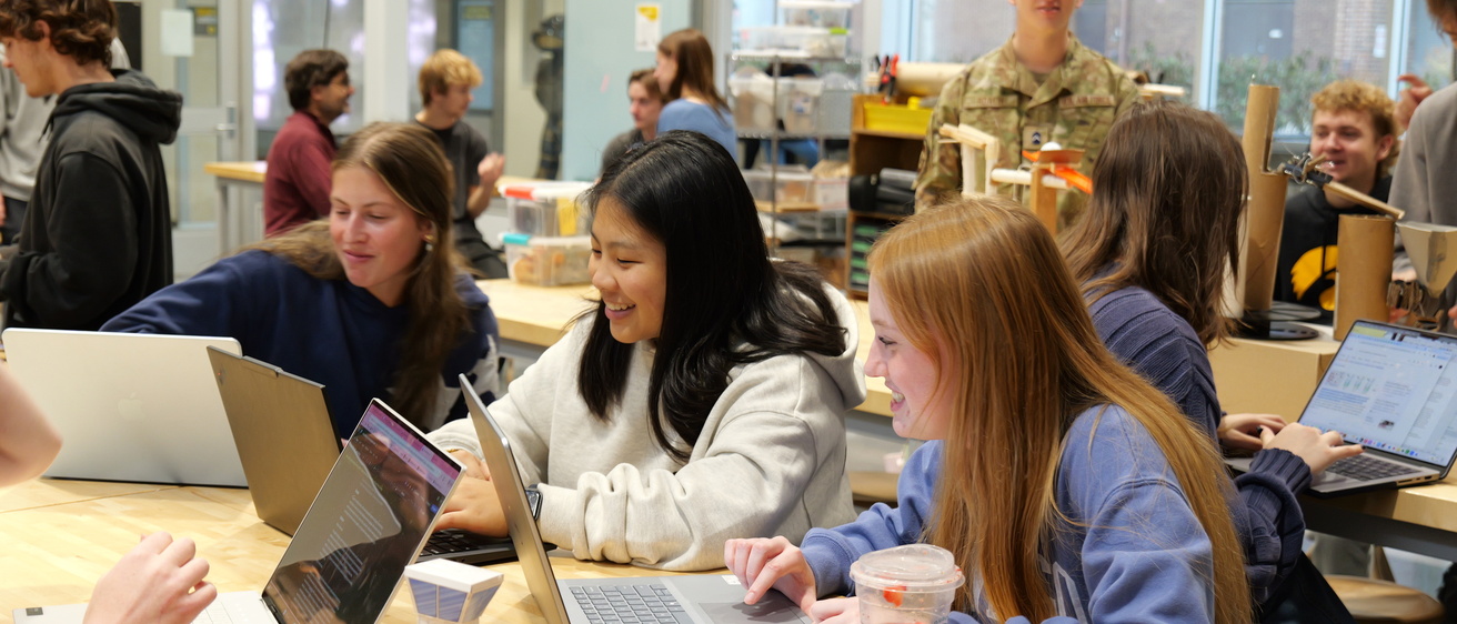 Students working on computers and with building materials in a classroom