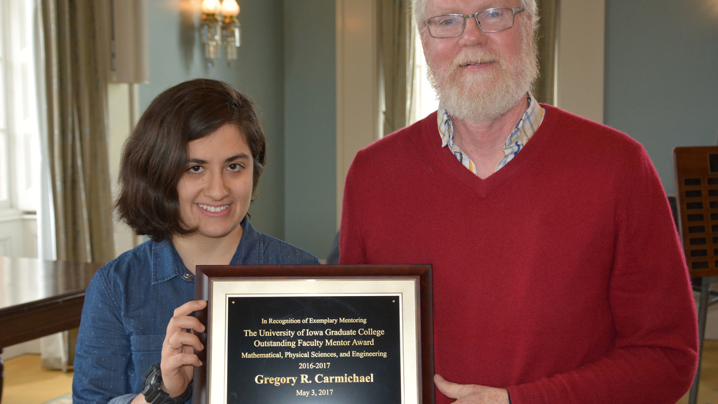 Greg Carmichael receiving the outstanding faculty mentor award from one of his students 