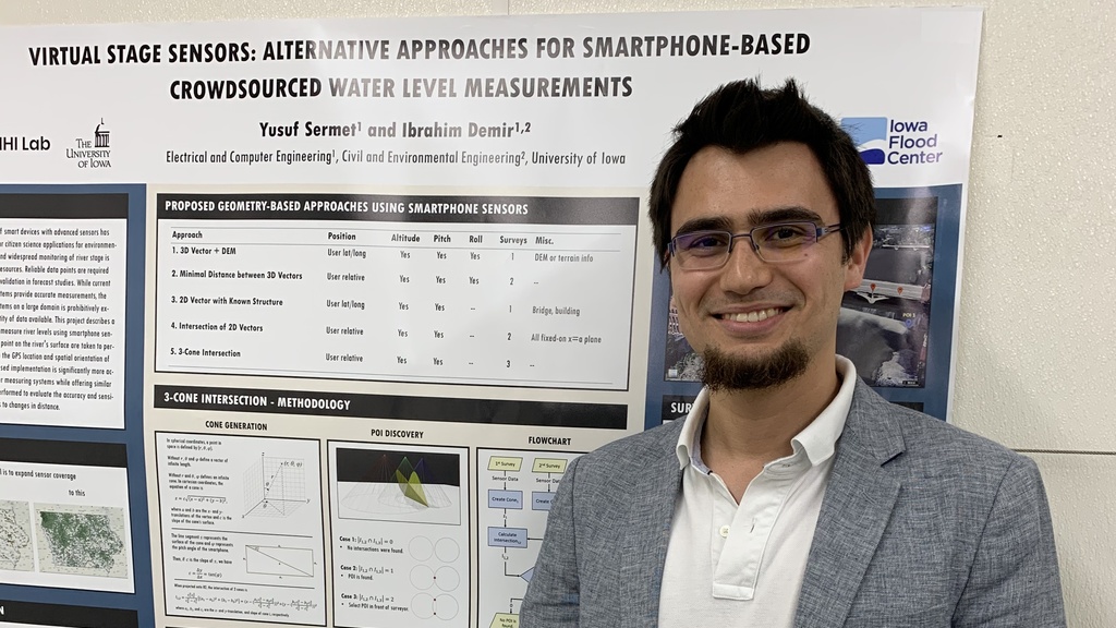 Yusuf Sermet holding his award from the Student Poster Competition. His poster is in the background.