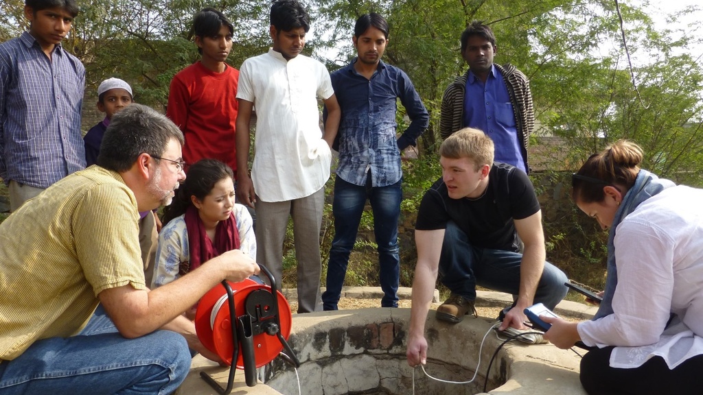 Students conducting research around a well