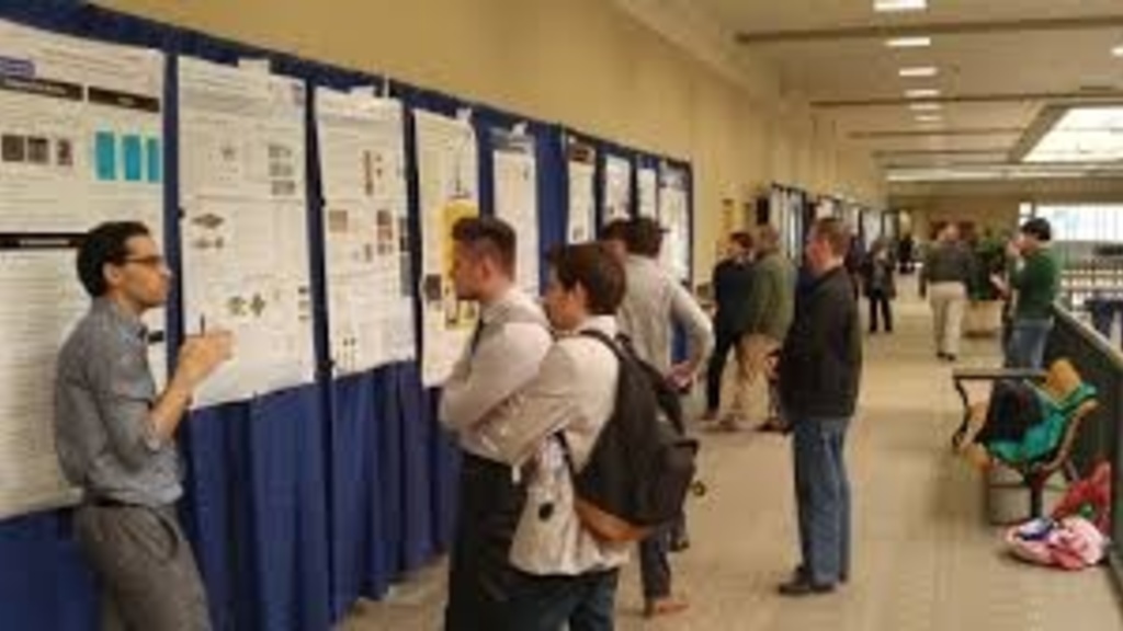 People viewing posters at the research open house