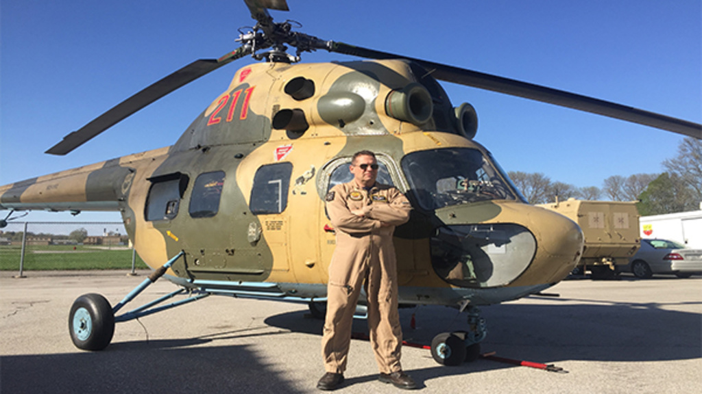 Tom Schnell standing in front of a helicopter
