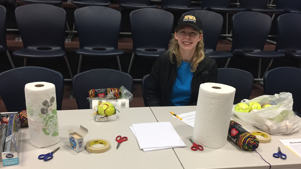 Engineering student sitting at a table full of craft supplies. 