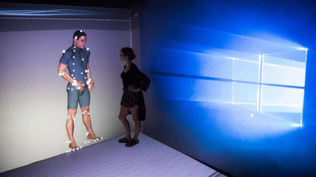 Woman looking at a projection of a 3D model of a man.