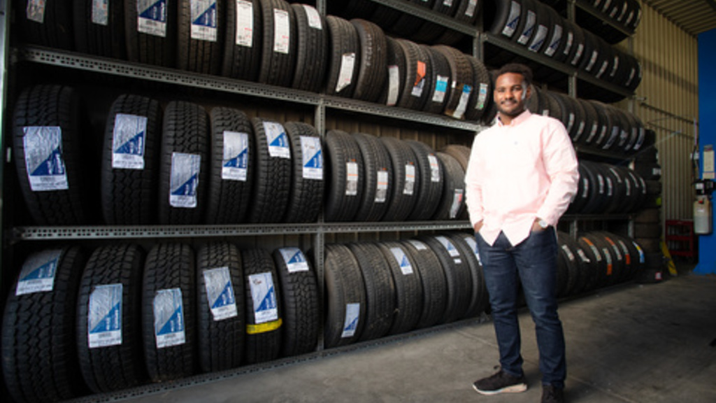 man standing in front of shelves full of tires