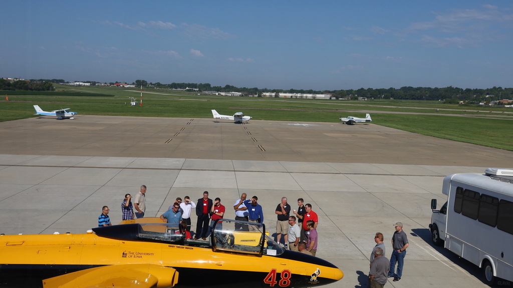 Image of yellow plane with group of people standing behind