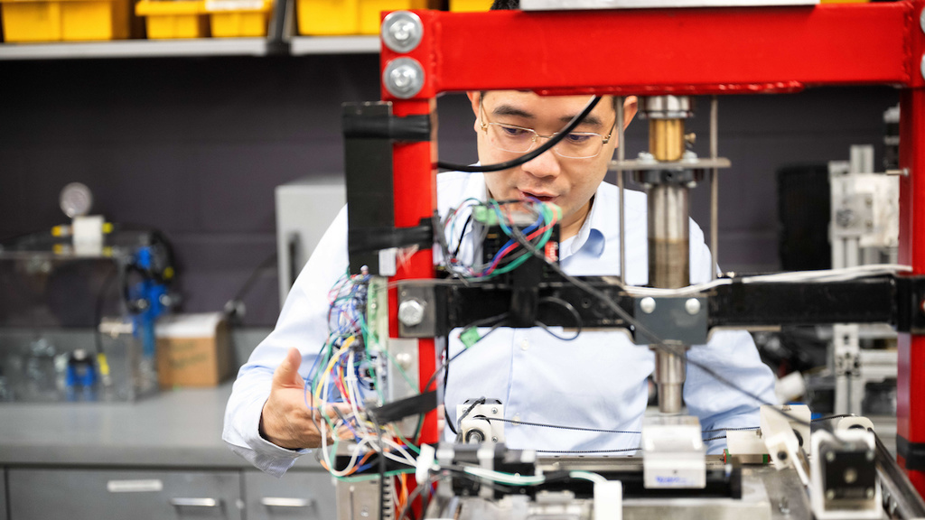 Xuan Song works with equipment in his lab