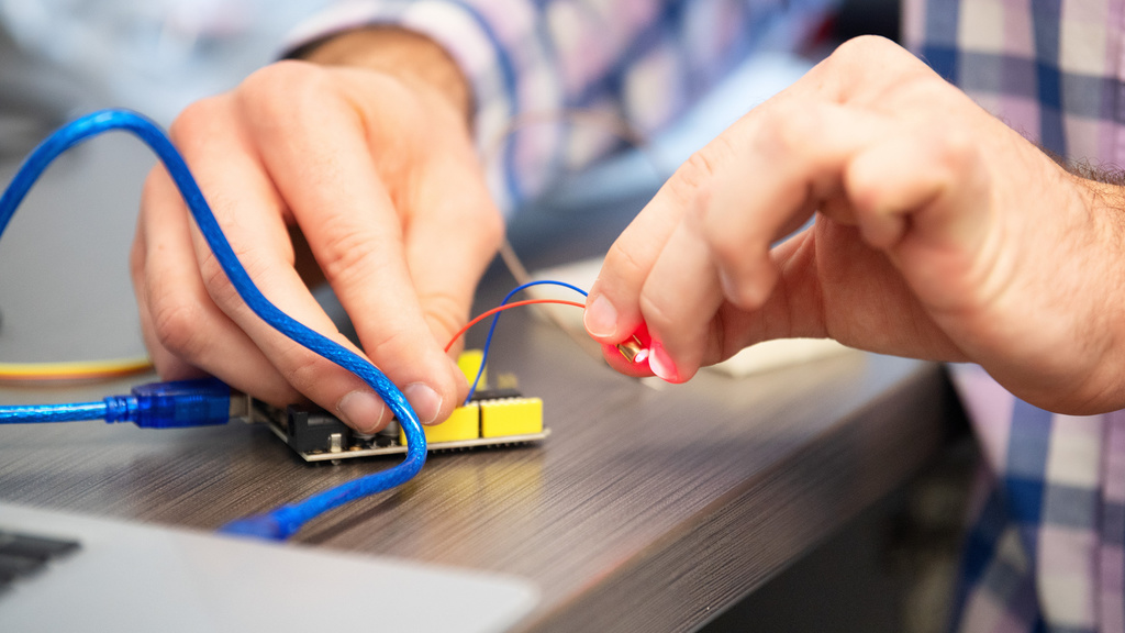 close up of someone working with small wires that are blue and red