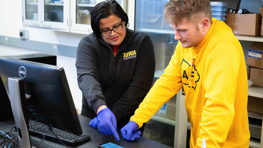 Fatima Toor works with a student in her lab