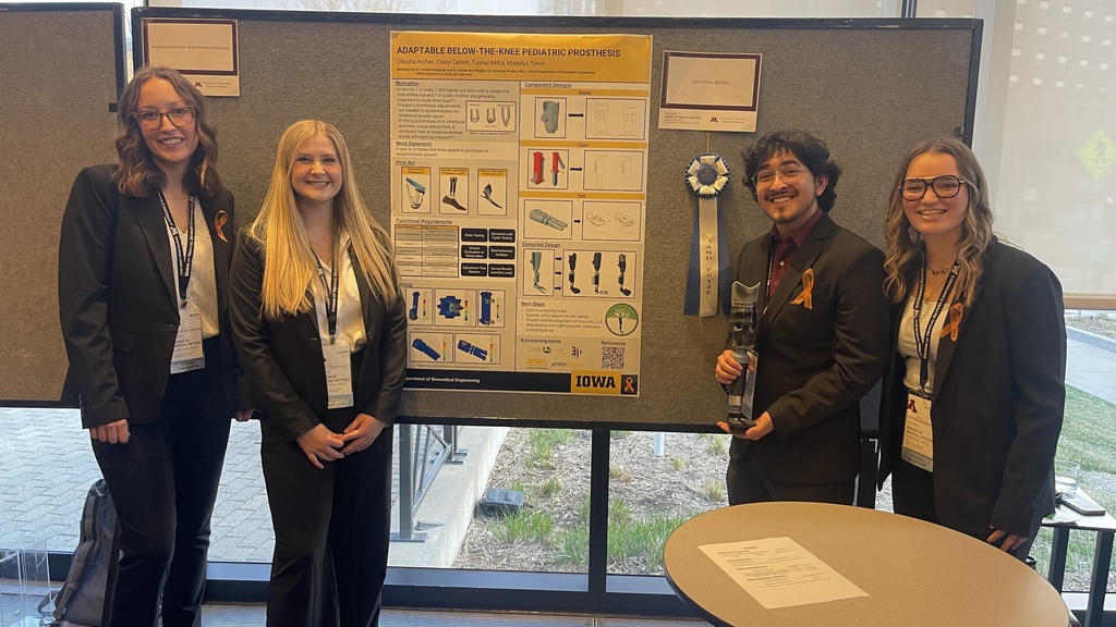 Four students standing by their research poster