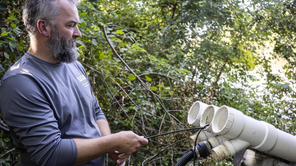 A person checks a stream sensor