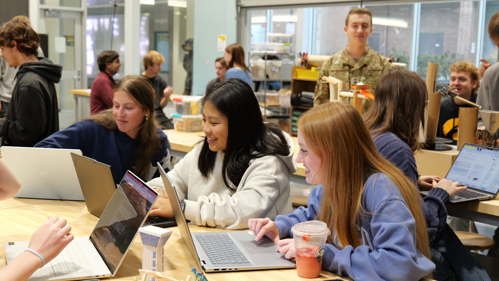 Students working on computers and with building materials in a classroom