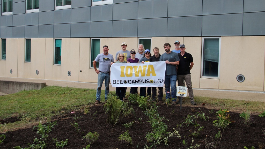 A group of people holding a "Bee Campus USA" sign