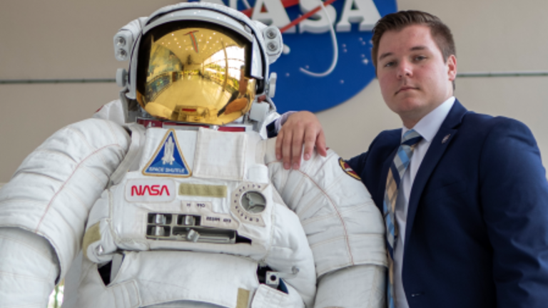 Mat McDonnell poses with an astronaut statue