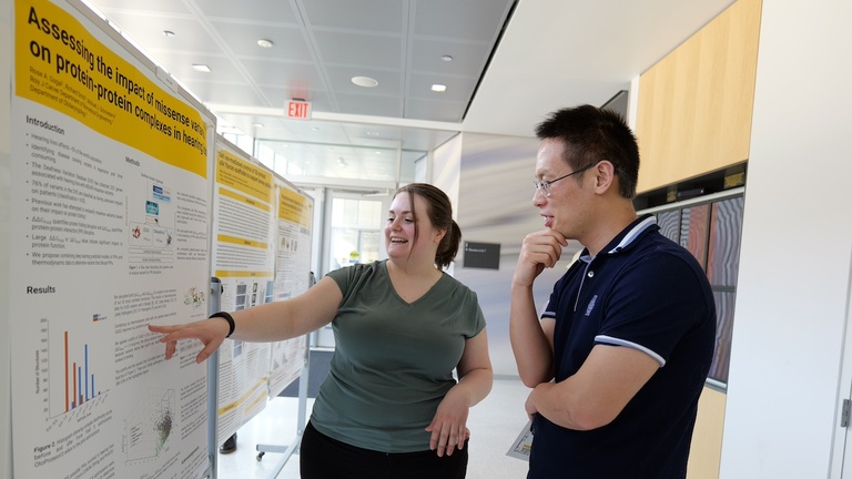 Two people discussing a research poster