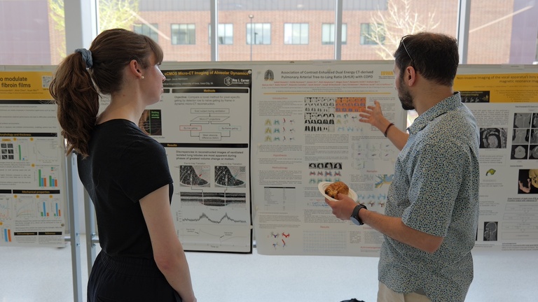 Two people discussing a research poster