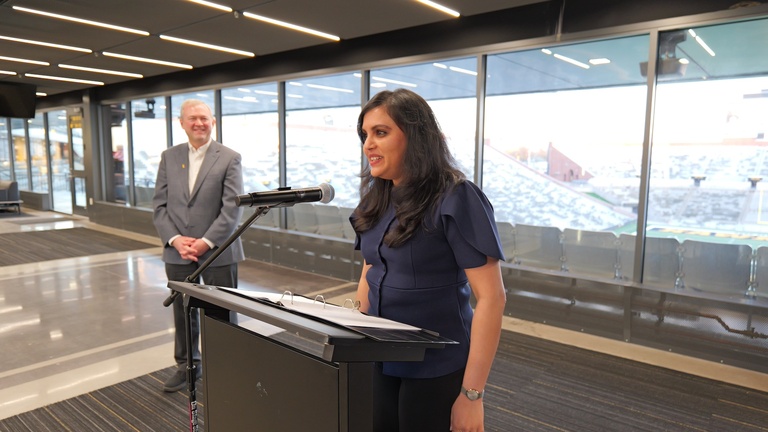 Attendee speaks at a podium during the honored alumni recognition ceremony at Kinnick Stadium.